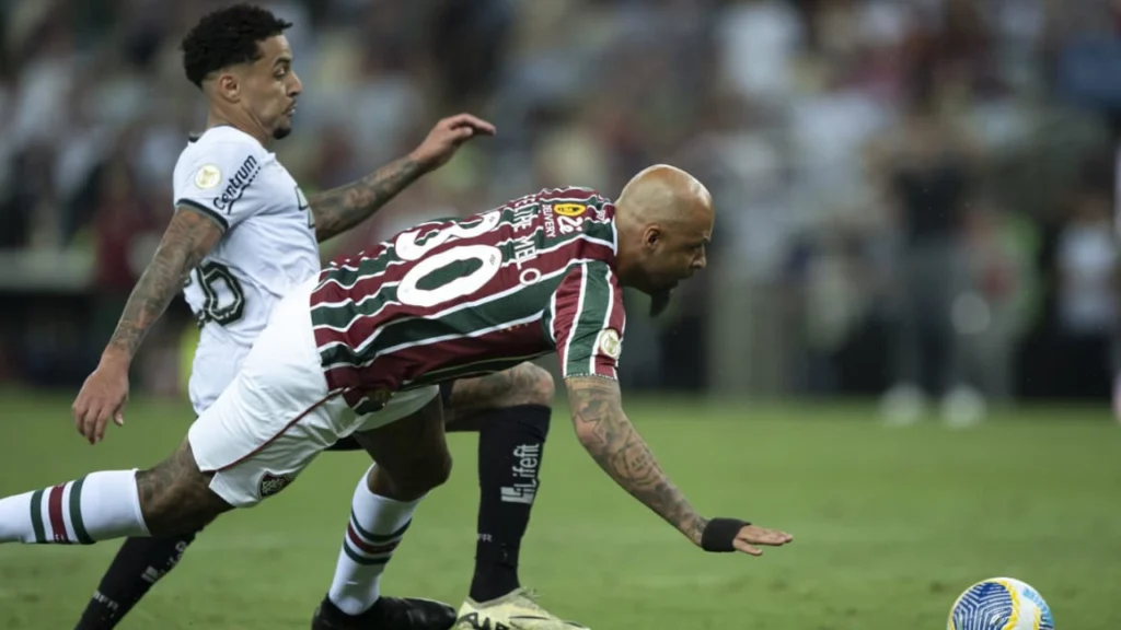 Felipe Melo, jogador do Fluminense, cai ao disputar a bola com um jogador do Botafogo em um lance do clássico no Maracanã.